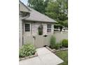 A fenced-in side entrance featuring tidy landscaping and a brick exterior with stone-paved path at 7536 Briarstone Dr, Indianapolis, IN 46227