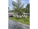 A well-maintained home with mature trees, a lush lawn, and a brick exterior with attached garage at 7536 Briarstone Dr, Indianapolis, IN 46227
