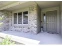 Inviting front entrance with a gray door, brick accents, and a sheltered concrete patio at 7741 Long Branch Dr, Indianapolis, IN 46259