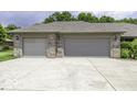 Attached two-car garage with gray doors, showcasing ample parking space and brick accents at 7741 Long Branch Dr, Indianapolis, IN 46259