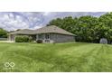 Expansive lawn surrounding a well-maintained single-story brick home with lush greenery at 7741 Long Branch Dr, Indianapolis, IN 46259