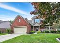 Charming two-story home with brick and siding, a well-manicured lawn, and an attached two-car garage at 8030 Parcrest Ct, Indianapolis, IN 46259