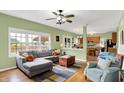 Comfortable living room with large windows, hardwood floors, stylish furniture, and a view into the adjacent kitchen at 8030 Parcrest Ct, Indianapolis, IN 46259
