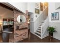 Elegant hallway with a brick accent wall and staircase leading to the upper level at 8140 Springwater W Dr, Indianapolis, IN 46256