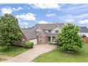 Expansive aerial view of a charming two-story brick home, showcasing its well-manicured lawn and idyllic setting at 8663 N Commonview Dr, McCordsville, IN 46055