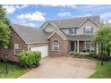 Beautiful two-story brick home features an attached garage, manicured lawn, and an inviting, classic design at 8663 N Commonview Dr, McCordsville, IN 46055