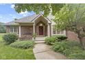 Inviting front entrance featuring a red door, classic columns, and landscaped garden at 9175 Lakewind Dr, Indianapolis, IN 46256
