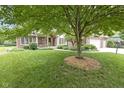 Well-maintained front yard showcases mature trees and landscaping, enhancing the curb appeal at 9175 Lakewind Dr, Indianapolis, IN 46256