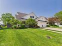 Beautiful two-story home with a lush green lawn, mature trees, and a convenient two-car garage at 9635 Shasta Dr, Fishers, IN 46038