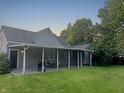 Back exterior view showcases the home's covered patio and spacious backyard at 1141 N Shadeland Ave, Indianapolis, IN 46219