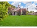 Charming home with a manicured lawn and mature trees under a blue, partly cloudy sky at 1141 N Shadeland Ave, Indianapolis, IN 46219