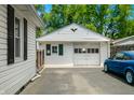 Detached garage features white siding, a traditional door, and parking space on a paved driveway at 120 Hoss Rd, Indianapolis, IN 46217