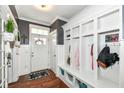 Inviting entryway features a built-in storage bench and coat rack, hardwood floors, and a welcoming front door at 1217 Old Vines Trl, Greenwood, IN 46143