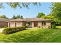 Well-maintained brick ranch with green lawn, mature trees, and an attached two-car garage at 1220 Pintail Ct, Columbus, IN 47201