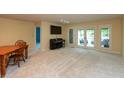 Spacious living room with neutral carpet, piano, dining table and patio access at 1220 Pintail Ct, Columbus, IN 47201