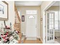 Inviting foyer features hardwood floors, a staircase, and a view into an adjacent room with a glass door at 13068 Lamarque Pl, Fishers, IN 46038