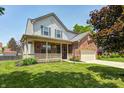 Lovely two-story home with front porch, landscaped yard, and a mix of brick and siding accents at 13068 Lamarque Pl, Fishers, IN 46038