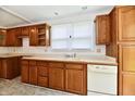 Functional kitchen featuring wood cabinets, neutral countertops, and natural light at 1346 W 27Th St, Indianapolis, IN 46208