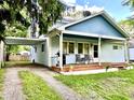 Exterior of home with a covered porch featuring chairs, a grill and an attached carport on the side at 1437 E Pleasant Run Pkwy S Dr, Indianapolis, IN 46203