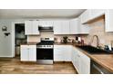 Modern kitchen with stainless steel appliances, white cabinetry, and wood countertops at 1445 Biloxi Ln, Beech Grove, IN 46107