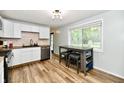 Bright kitchen featuring white cabinets, stainless steel appliances, and a dining area at 1445 Biloxi Ln, Beech Grove, IN 46107