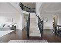 Grand foyer with dark hardwood floors, staircase with black banister, and open archways leading to other rooms at 15201 Slateford Rd, Noblesville, IN 46062