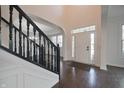 Elegant foyer with hardwood floors, black stair railing, and arched doorways at 15201 Slateford Rd, Noblesville, IN 46062