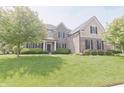 Lovely two-story home boasts manicured landscaping, a brick facade, and a welcoming entrance at 15201 Slateford Rd, Noblesville, IN 46062