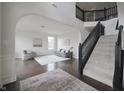 Bright and airy living room featuring dark wood floors, neutral furniture, and staircase with black banister at 15201 Slateford Rd, Noblesville, IN 46062