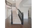 Staircase with carpet steps and a black decorative banister and wood flooring at 15201 Slateford Rd, Noblesville, IN 46062