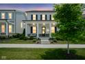 Charming two-story home with a welcoming front porch with swing under a stunning evening sky at 15557 Starflower Dr, Westfield, IN 46074