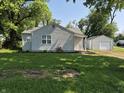 Single-story home with a detached garage and large lawn at 1584 Shady Ln, Columbus, IN 47201