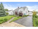 Charming two-story home with a well-manicured lawn and a detached two-car garage at 1621 Beeler Ave, Speedway, IN 46224