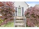 Inviting entrance with a decorative glass door framed by lush, mature landscaping at 1621 Beeler Ave, Speedway, IN 46224