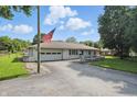 View of the charming one-story home featuring an attached garage, and well-maintained lawn at 17 E Beechwood Ln, Indianapolis, IN 46227
