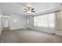 Bright living room with neutral carpeting, a ceiling fan, and an abundance of natural light at 17 E Beechwood Ln, Indianapolis, IN 46227