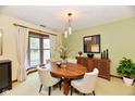Stylish dining room with modern lighting, a bay window, and a classic wood table at 1783 Cloister Dr, Indianapolis, IN 46260