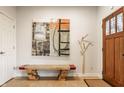 Inviting foyer with a wooden bench, modern art, and an elegant stained glass front door at 2020 N Park Ave, Indianapolis, IN 46202