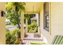 Inviting covered front porch with a hanging swing, planters, and bright yellow siding details at 2020 N Park Ave, Indianapolis, IN 46202