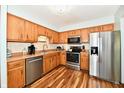 Well-lit kitchen featuring stainless steel appliances, wood cabinets, and vinyl flooring at 2442 N Willow Way, Indianapolis, IN 46268