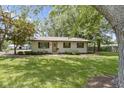 View of cozy one-story home featuring tidy landscaping, shaded by mature trees in front yard at 255 N Pasadena Rd, Noblesville, IN 46062