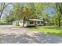 Quaint one-story home with attached garage, complemented by a spacious driveway and green front lawn at 255 N Pasadena Rd, Noblesville, IN 46062