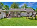 Large backyard with covered patio, swing set, and mature trees perfect for outdoor enjoyment at 267 S Grant Ave, Indianapolis, IN 46201