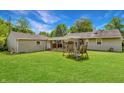 Spacious backyard featuring a covered patio, lush green grass, and a classic swing set at 267 S Grant Ave, Indianapolis, IN 46201
