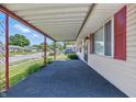 View of the spacious covered porch with red support beams and a glimpse of the peaceful neighborhood at 2908 N Routiers Ave, Indianapolis, IN 46219