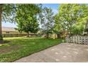 Spacious backyard featuring mature trees, a play set, and a patio area at 3225 25Th St, Columbus, IN 47203