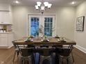 Cozy dining room with rustic table, modern chandelier, and French doors providing natural light at 4619 N Park Ave, Indianapolis, IN 46205