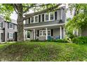 Traditional home with a covered porch, featuring classic shutters and a mature tree in the front yard at 4619 N Park Ave, Indianapolis, IN 46205