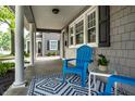 Relaxing front porch with blue Adirondack chairs, a patterned rug, and views of the landscaped yard at 4619 N Park Ave, Indianapolis, IN 46205