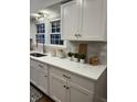 Bright kitchen featuring white cabinets, quartz countertops, tiled backsplash, and modern gold hardware at 4619 N Park Ave, Indianapolis, IN 46205